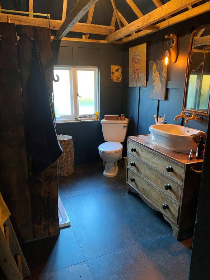 PATINA-BLUE-RUST-METALLIC-PORCELAIN-TILE. Image shows blue metallic tiles on floor of bathroom with wooden drawers