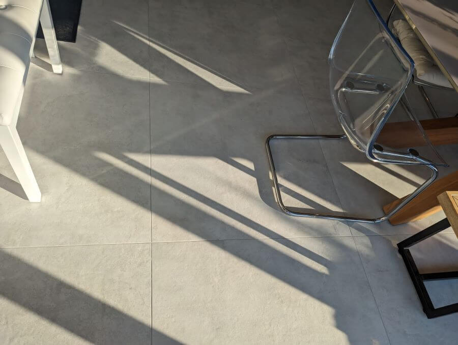 BEAT-WHITE. Image shows white concrete effect tile on floor of living area