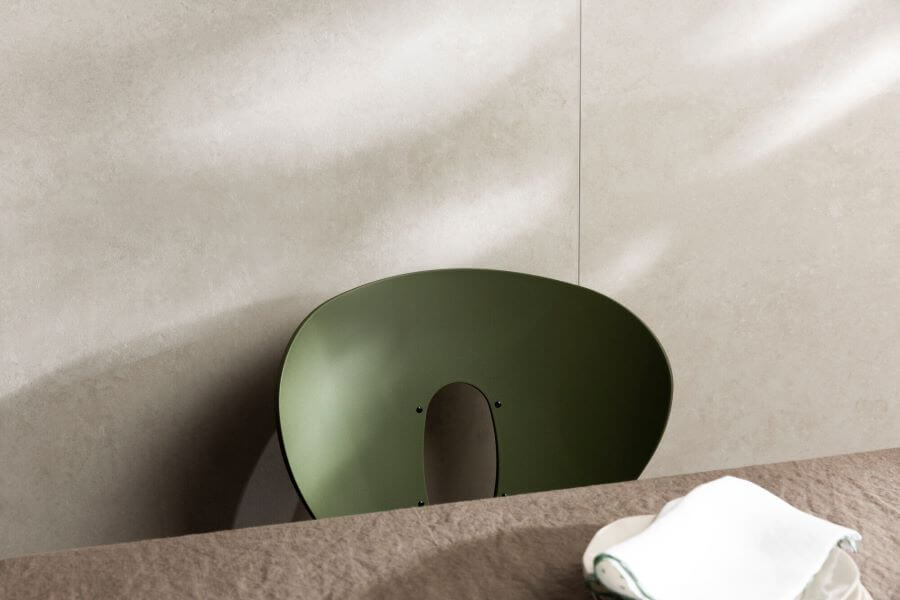 METRO-BONE-CEMENT-LOOK-PORCELAIN-TILE. Image shows cream tiles with green chair and a table.