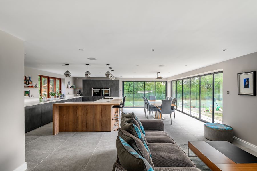 METRO-SILVER. Image shows silver floor tiles in dining area with dining table and chairs and kitchen and brown sofa in foreground