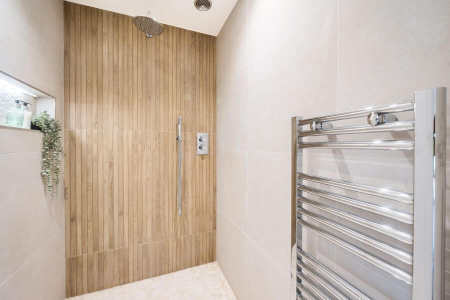 SEASON-CARAMEL. Image shows wood effect ceramic wall tiles with shower with concrete effect tile on walls and floor