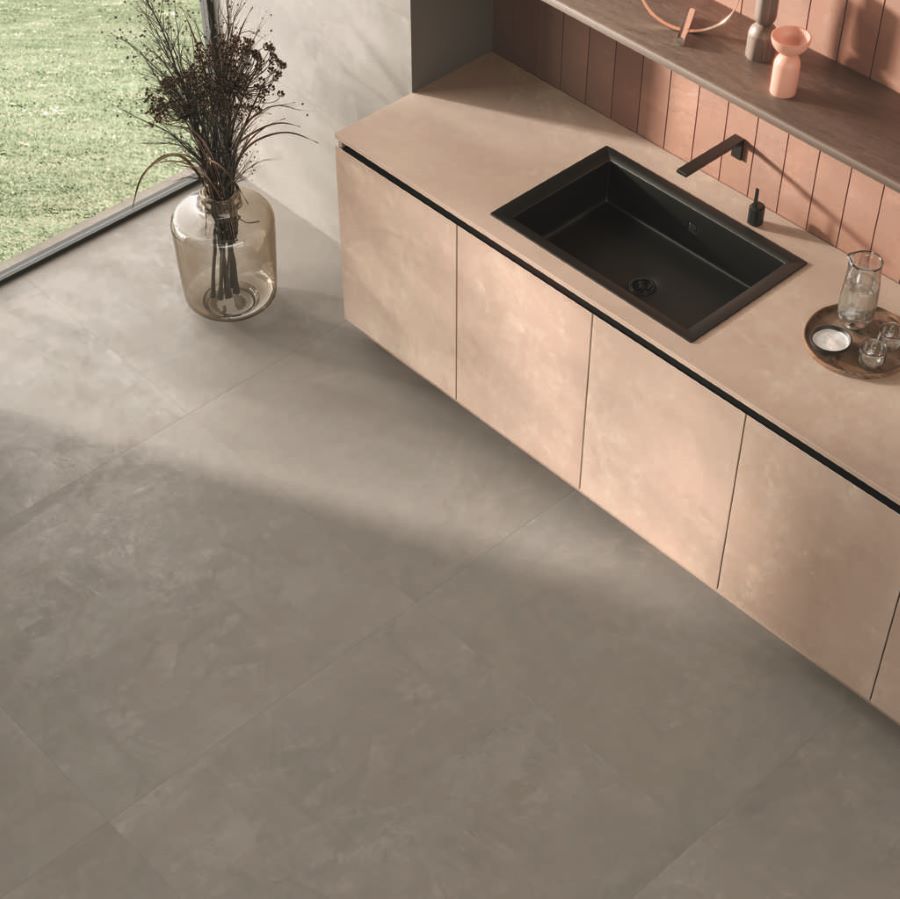 BLEND-CEMENT-LOOK-PORCELAIN-TILE-CLOSEUP. Image shows putty cement look porcelain tile in kitchen with pink units shot from above