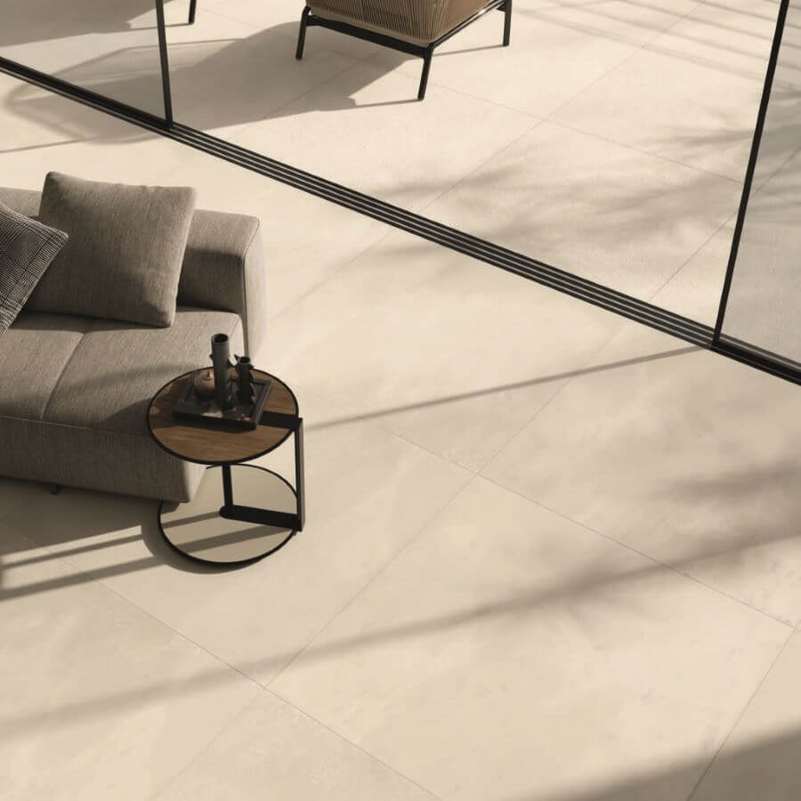 BLEND-MATCHSTICK-CEMENT-LOOK-PORCELAIN-TILE-INSIDE-OUTSIDE. Image shows cream cement look porcelain tile inside lounge and outside onto patio