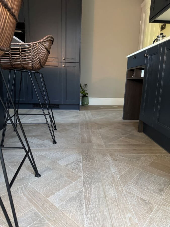 Louis porcelain floor tile that looks like wood, image shows a close up of wood effect floor tiles in a kitchen.