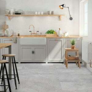 Image shows Bliss grey porcelain large stone tiles in kitchen with grey cabinets