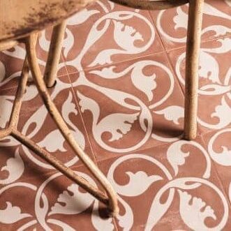 MODE_PATTERNED_CERAMIC_TILES_CLARET-SWATCH. Image shows red and cream patterned tile on floor with chairs