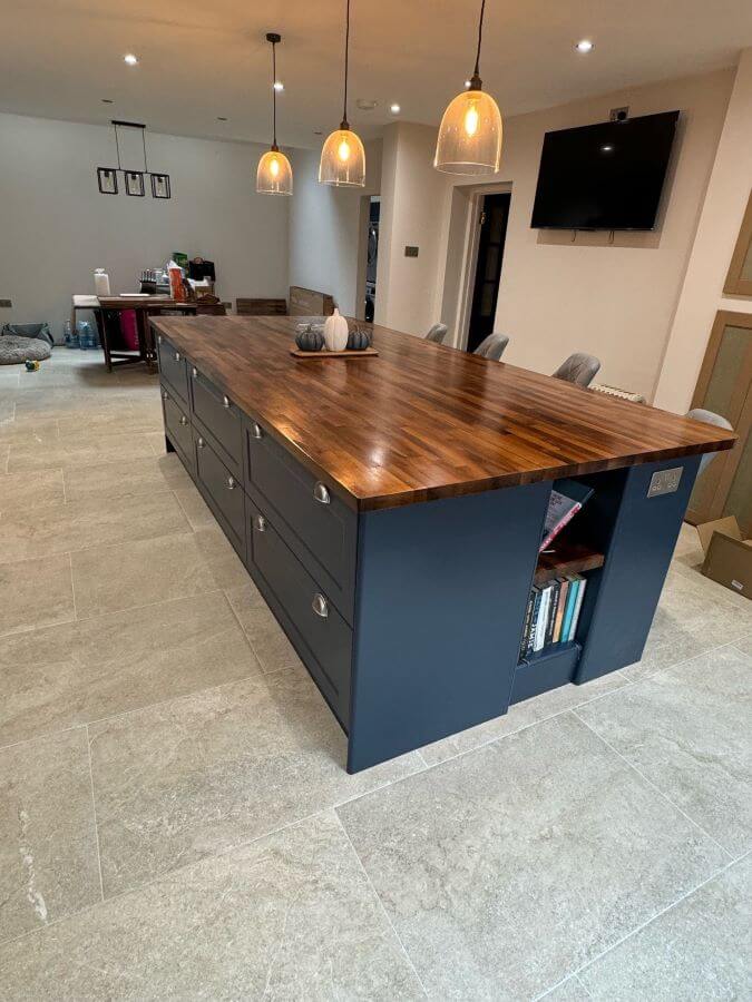5. Image shows tiled kitchen floor with taupe stone effect tiles and a navy blue kitchen unit with wooden worktops
