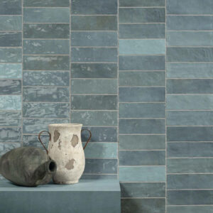Blue Adore Aqua ceramic Spanish tiles displayed on a wall with vases in front.
