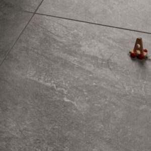 Alpine Scorch brown quartz-effect porcelain tile swatch displayed alongside children's toys, highlighting the durable and earthy stone-coloured texture.