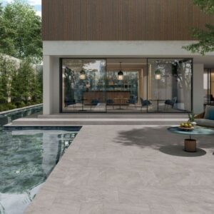 ALPINE-SEPIA-QUARTZ-EFFECT-PORCELAIN-TILE. Image shows light grey quartz effect porcelain tile around a swimming pool with outdoor furniture