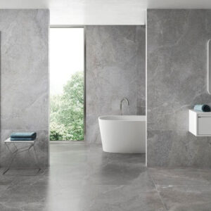 BLISS-GREY-PORCELAIN-LARGE-STONE-TILES. Image shows grey porcelain large stone tiles on bathroom wall and floors with shower, bath and vanity unit