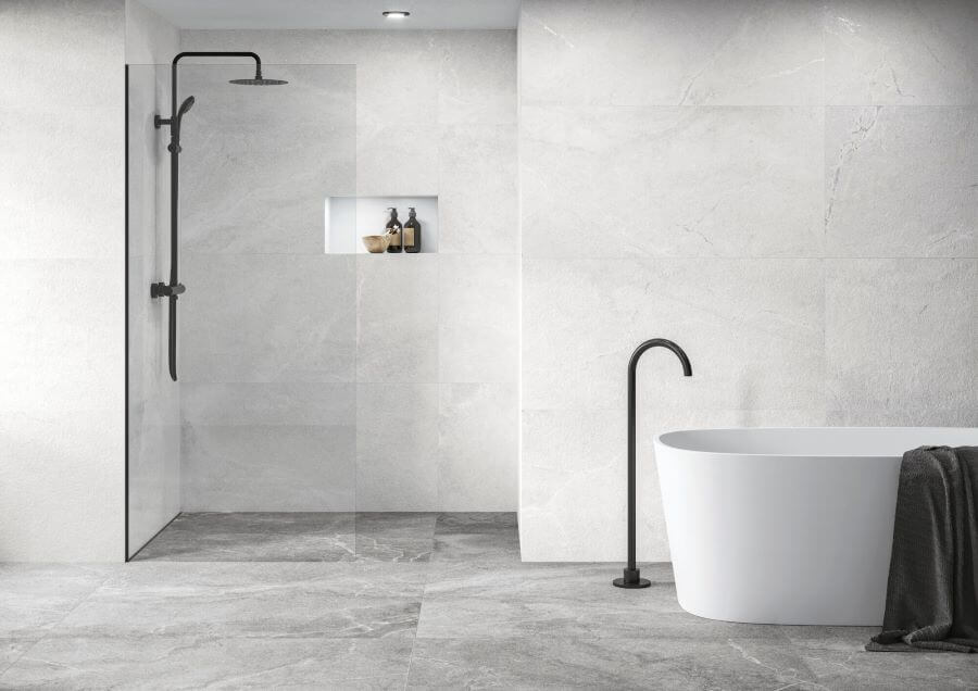 BLISS-WHITE-PORCELAIN-LARGE-STONE-TILES. Image shows white porcelain large stone tiles on bathroom walls with bath and shower