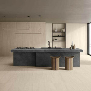 Ethos Sand. Image shows sand stone look porcelain tile on kitchen floor with large grey stone island unit