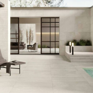 ETHOS-SHORE-STONE-LOOK-PORCELAIN-TILE-OUTSIDE. Image shows cream stone look porcelain tile around a pool