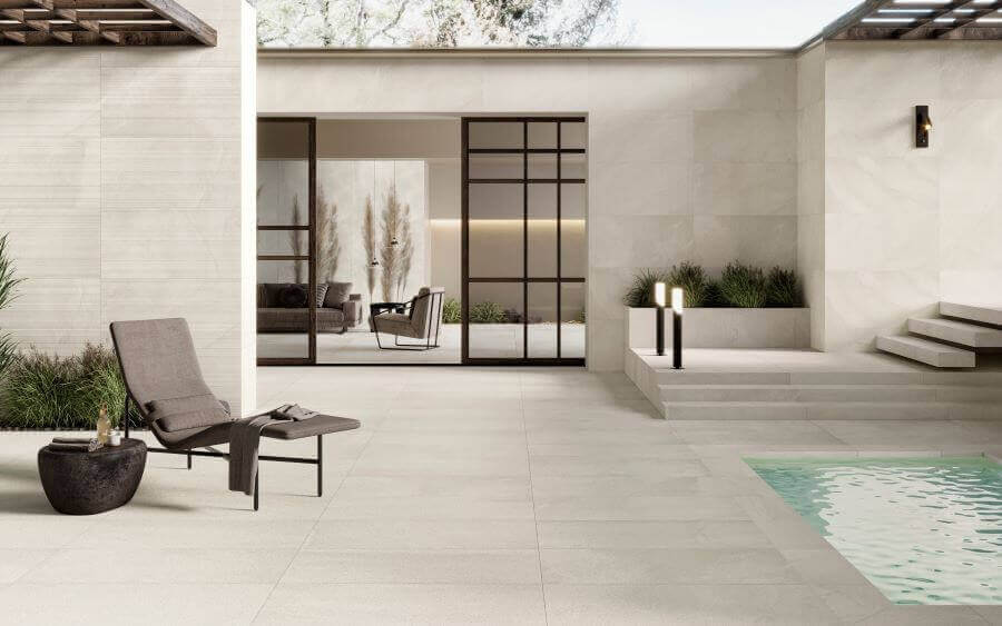 ETHOS-SHORE-STONE-LOOK-PORCELAIN-TILE-OUTSIDE. Image shows cream stone look porcelain tile around a pool