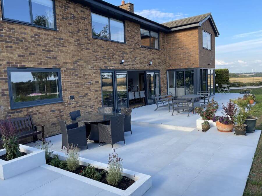 Poise Pebble pavers. Image shows light taupe 2cm porcelain pavers in garden