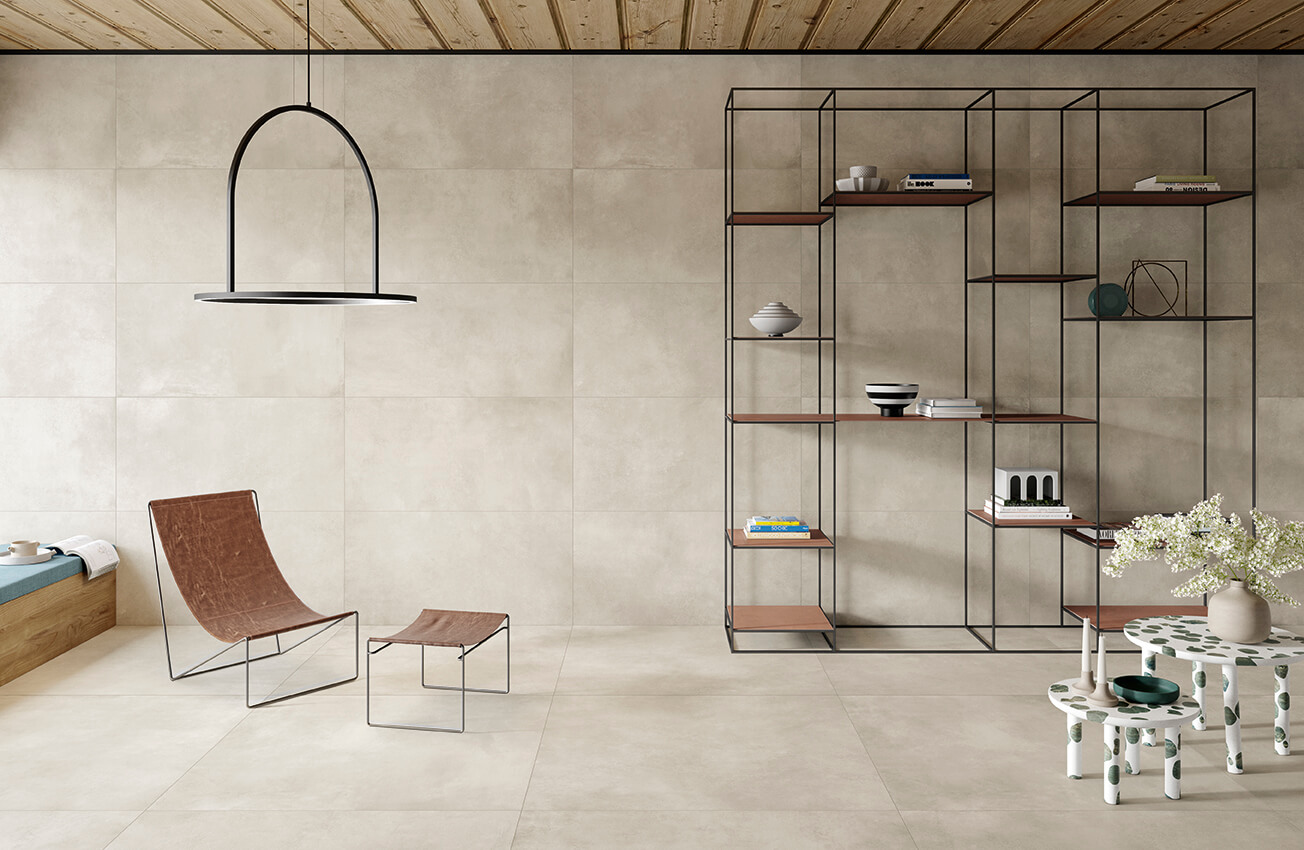 STRIDE-ELEMENT-CONCRETE-LOOK-PORCELAIN-TILE. Image shows light concrete look porcelain tile to wall and floor with chair