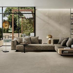 ASPECT-ASH-PORCELAIN-TILE-THAT-LOOKS-LIKE-SLATE. Image shows ash porcelain tile that looks like slate in lounge with sofa and shelving units