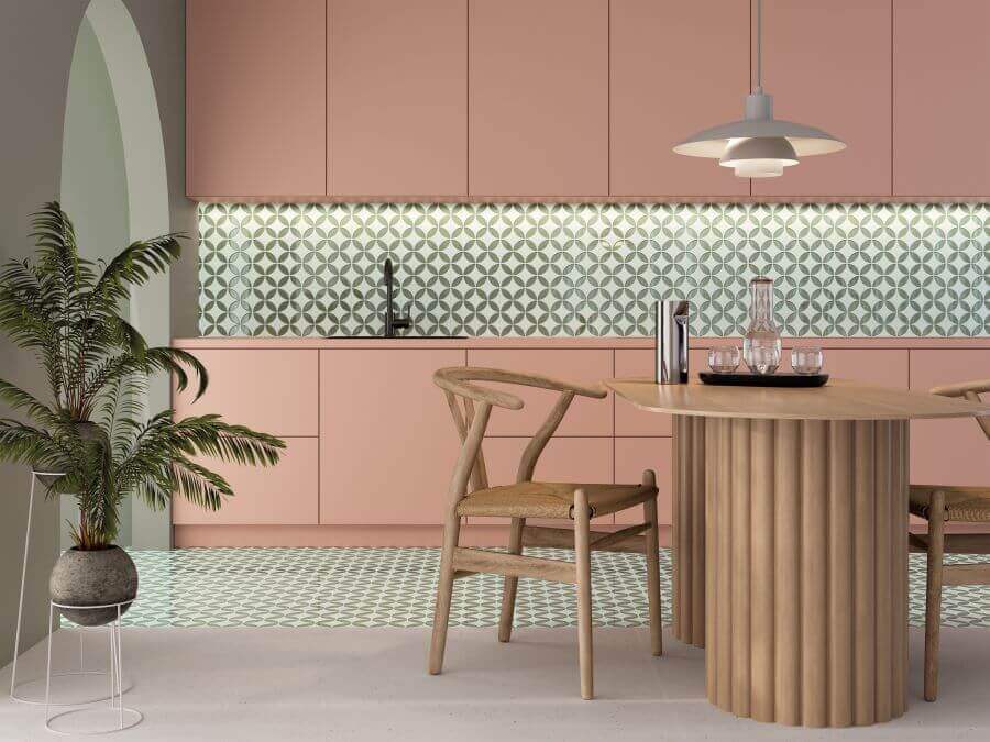 BLOOM-GREEN-PORCELAIN-FEATURE-TILES-KITCHEN. Image shows green and white porcelain feature tiles in kitchen with pink kitchen cabinetry and wooden table and chairs