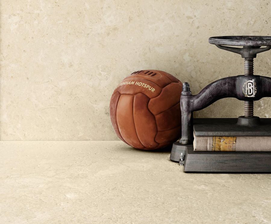 FLOW-SHELL-STONE-EFFECT-PORCELAIN-TILE. Image shows cream tile with American football
