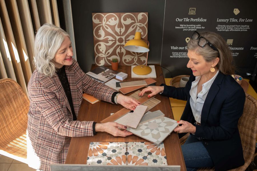 DSC_6297. Image shows two ladies looking over tiles together.