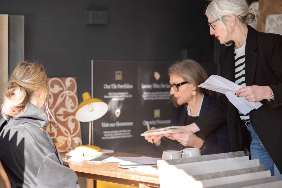 TheTilePortfolio032. Image shows three ladies around desk looking at samples