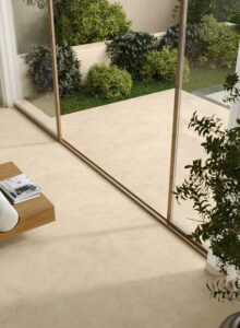 Lounge and garden featuring Joy indoor-outdoor flooring tiles in Sand colour.