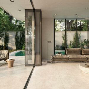 NEST-CONCRETE-EFFECT-TILE-SAND-1. Image shows concrete effect tile in sand in lounge and out onto patio