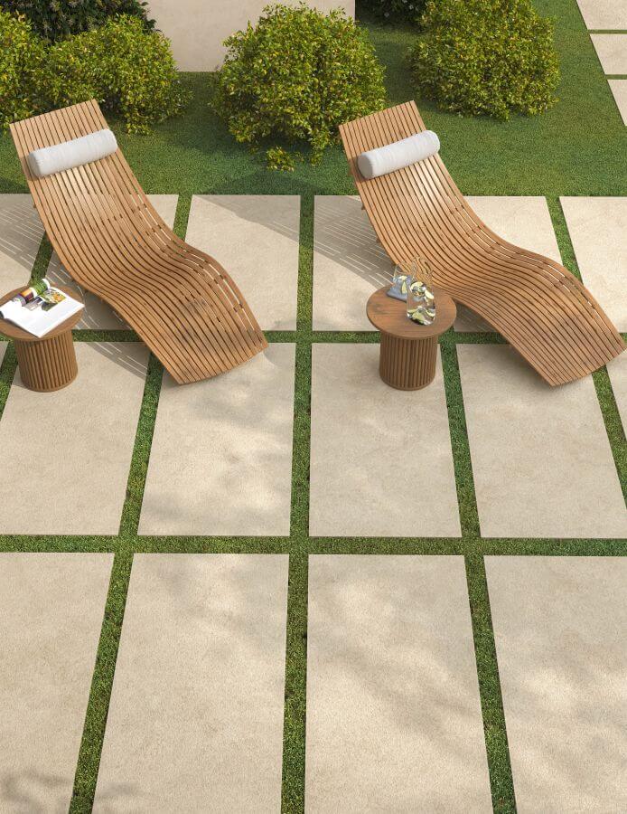 JOY-1200-X-600-PAVING-SLABS-SAND. Image shows sand coloured paving slabs as stepping stones on grass