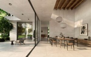 NEST-THE-LATEST-BEIGE-TILES-BONE. Image shows latest beige tiles in a dining room with a large dining table and an outside area in the same tiles
