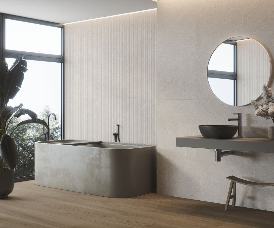 ELEMENT-PORCELAIN-NATURAL-STONE-EFFECT-TILE-SAND-1. Image shows natural stone effect tile in light beige in bathroom with a bath and vanity unit in grey