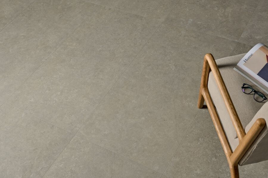 FUSION-STONE-EFFECT-FLOORING-FOSSIL. Image shows grey stone effect flooring with a chair
