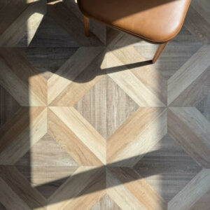 VERSAILLES-MARQUETRY-PORCELAIN-TILE-LIGHT. Image shows light versailles marquetry porcelain tile with brown leather chair