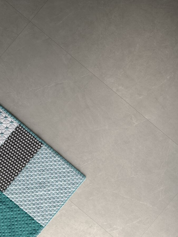 Poise greige porcelain tiles in a minimalist design, offering a soft neutral backdrop with a turquoise bath mat.