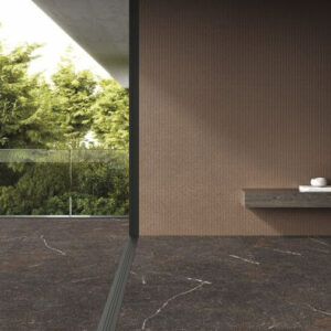 An interior view of the Sombra dark marble porcelain tile leading to an outdoor area, creating a high-end, luxurious look with its continuous white veining