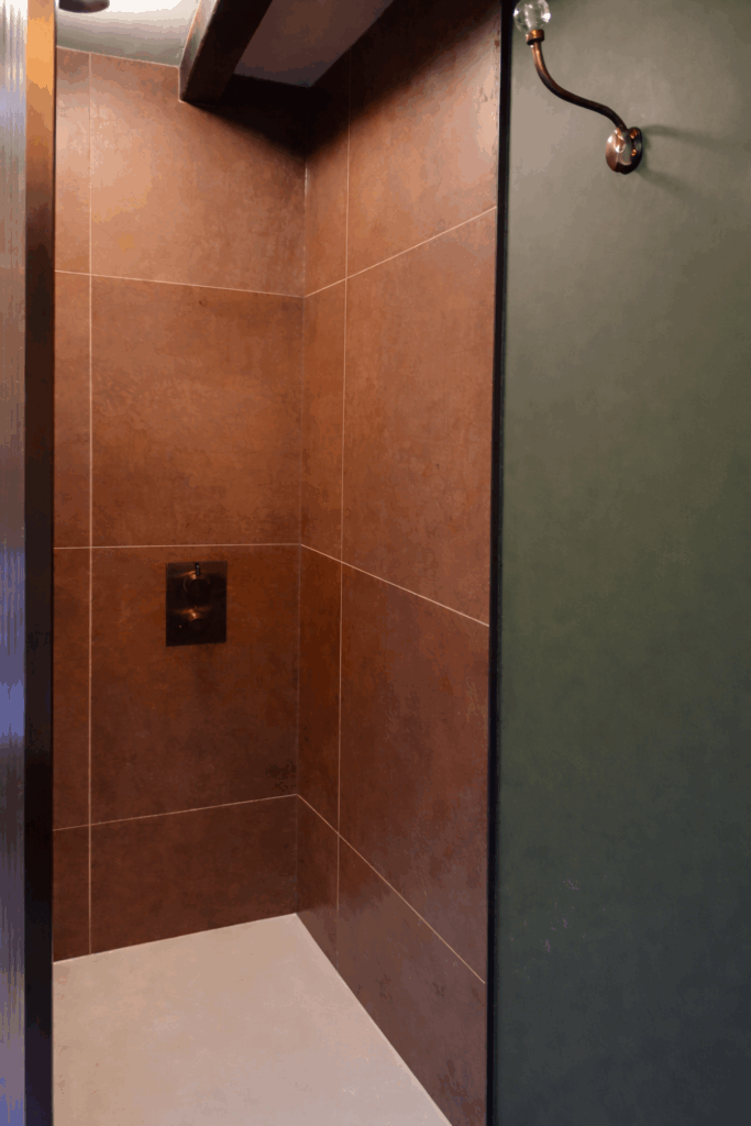 Industrial-style kitchen splashback featuring 600x600 Etch Metallic Bronze porcelain tiles with a textured, rust-effect finish.