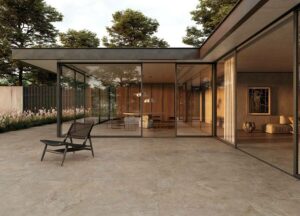 A patio area at sundown with warm toned porcelain tiles and a contemporary home in the background