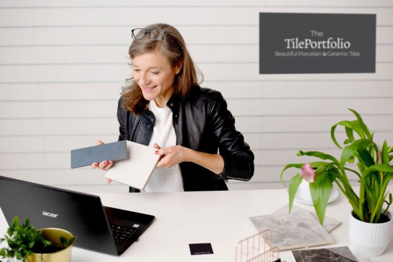 Image shows lady at desk showing customers tiles via laptop.